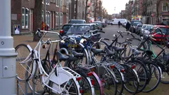 Fietsen geparkeerd aan stoep in Amsterdamse buurt met oude sociale woningbouw