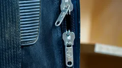 Blauwe en zwarte leren reistas met stof en patina, close-up van ritssluiting